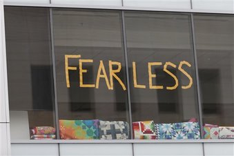 Trabajadores de un edificio de oficinas colocan un letrero con la palabra Fearless (valiente) en referencia a uno de los títulos de uno de los álbumes de Taylor Swift antes del comienzo de su juicio civil el viernes 11 de agosto de 2017, en Denver. Un ex guardaespaldas de Taylor Swift dijo el viernes que vio a un locutor meter su mano debajo la falda de la cantante. El incidente habría ocurrido un momento antes de que les tomaran una fotografía previo a un concierto de 2013 en Denver. El locutor David Mueller niega haber tocado a Swift y la ha demandado por 3 millones de dólares diciendo que arruinó su carrera. Swift lo contrademandó afirmando que sufrió una agresión sexual.