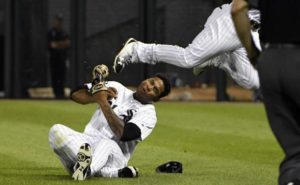 El jugador de los Medias Blancas, Willy García, en el suelo, es golpeado en la cabeza por la rodilla de su compañero Yoan Moncada, centro, durante un partido contra los Azulejos de Toronto el lunes, 31 de julio de 2017, en Chicago.