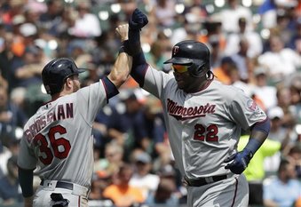 El bateador designado de los Mellizos de Minnesota, el dominicano Miguel sanó (22), es felicitado en el plato por Robbie Grossman después de que ambos anotaran con el jonrón de dos carreras del primero durante la tercer entrada del partido contra los Tigres de Detroit, en Detroit, el domingo 13 de agosto de 2017.