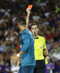 El árbitro Ricardo de Burgos, derecha, le enseña la tarjeta roja al atacante del Real Madrid Cristiano Ronaldo durante el partido de ida de la Supercopa de España contra Barcelona el domingo, 13 de agosto del 2017. Cristiano fue suspendido el lunes por cinco partidos por empujar al árbitro y por la expulsión.
