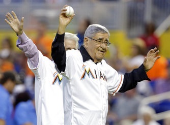 En esta foto del 27 de septiembre de 2013, el comentarista de béisbol Felo Ramírez saluda al público antes de realizar el primer lanzamiento en un partido entre los Marlins de Miami y los Tigres de Detroit, en Miami. Ramírez falleció el lunes, 21 de agosto de 2017, a los 94 años. (AP Foto/Lynne Sladky, Archivo).