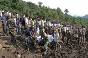 Soldados y rescatistas recuperan cuerpos de dos autobuses, dos automóviles y una motocicleta que fueron cubiertos de lodo tras un deslizamiento de tierra causado por lluvias monzónicas en el norte de la India el domingo 13 de agosto de 2017.