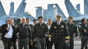 El primer ministro de Japón, Shinzo Abe, el vice primer ministro de Gobierno y ministro de Finanzas, Taro Aso y el entonces ministro de Defensa de Japón, Gen Nakatani, visitan el portaviones USS Ronald Reagan en la bahía de Sagami, Japón (archivo).