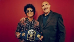 Bruno Mars, izquierda, conoce al luchador retirado Bruno Sammartino, derecha, mientras Mars sostiene una réplica de un cinturón de campeonato de Sammartino en el marco del concierto de la gira de Mars 24K Magic World Tour en Pittsburgh en una fotografía de archivo del 22 de agosto de 2017. El astro pop y el luchador retirado se conocieron el martes después de que Sammartino supiera que Mars, cuyo nombre verdadero es Peter Gene Hernandez, fue apodado Bruno por su padre porque era un bebé “corpulento”.