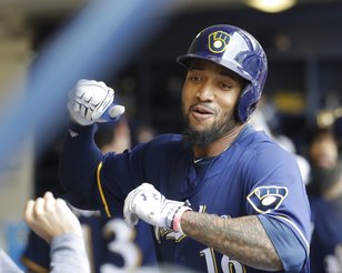 El dominicano Domingo Santana, de los Cerveceros de Milwaukee, es felicitado en la cueva, luego de batear un jonrón de tres carreras como local, ante los Rojos de Cincinnati, el domingo 13 de agosto de 2017