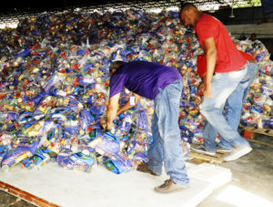 Empleados de Comedores Económicos preparan raciones alimenticias.