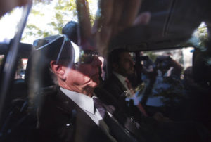 El presidente del Comité Olímpico Brasileño, Carlos Nuzman, sale de su casa escoltado por las autoridades tras una redada de la policía el martes, 5 de septiembre de 2017, en Río de Janeiro. (AP Foto/Silvia Izquierdo)