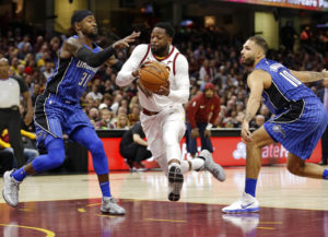 Dwyane Wade, centro, de los Cavaliers de Cleveland, se dirige a la canasta entre Terrence Ross, izquierda, y Evan Fournier, del Magic de Orlando, en Cleveland. Archivo (AP Foto/Tony)