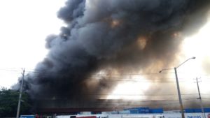 Incendio hace colapsar almacén en el kilómetro 12 1/2 de la autopista Duarte; al lado hay planta de gas natural. (Foto Suedi León)