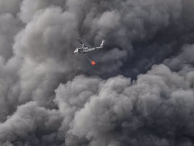 Helicóptero de la Fuerza Aérea Dominicana busca agua en el río Manoguayabo para zofocar el fuego en almacén de PlazaLama (Foto cortesía de @MisaelRincon)