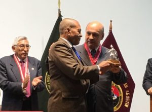 El periodista y relacionista público dominicano Santos Aquino Rubio (izquierda), recibe el Chasqui de Plata de la Confiarp durante un evento en Perú.