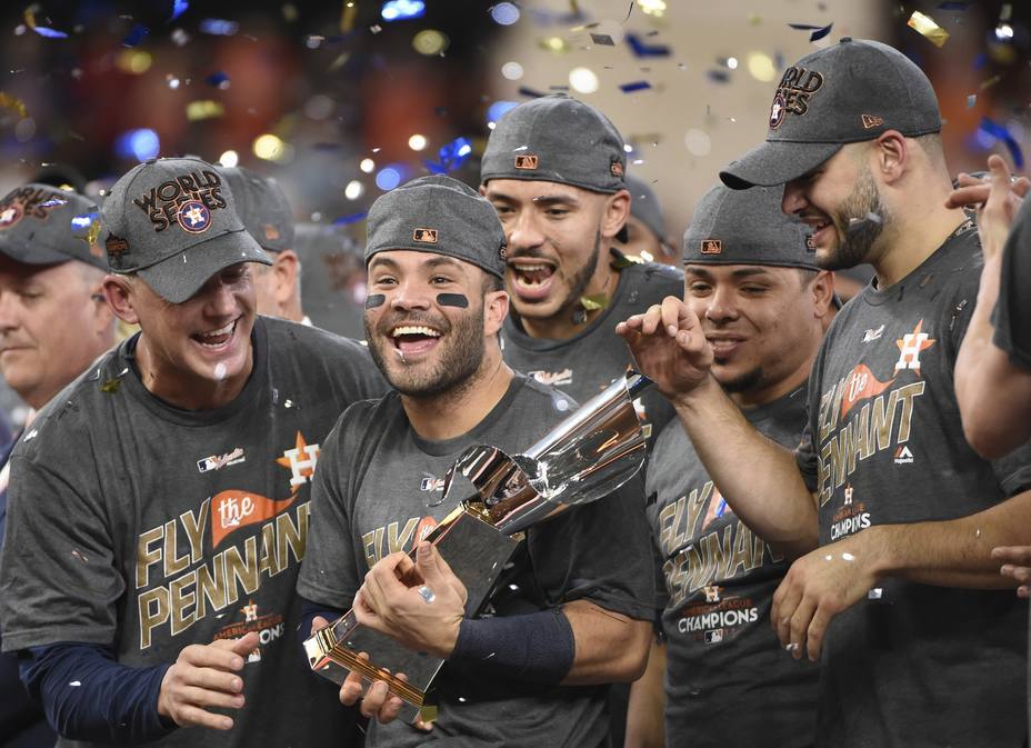 El venezolano José Altuve, de los Astros de Houston, alza el trofeo acompañado de sus compañeros, tras la victoria sobre los Yanquis de Nueva York en la Serie de Campeonato de la Liga Americana, el sábado 21 de octubre de 2017 (AP foto/David J. Phillip)