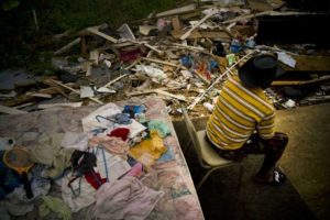 Efraín Díaz Figueroa pasa la tarde del lunes 9 de octubre de 2017 sentado en una silla junto con los restos de la casa de su hermana que quedó destruída luego del paso del huracán María en San Juan, Puerto Rico, tras el paso de María. (AP)