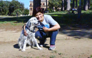 Foto sin fecha distribuida el jueves 12 de octubre de 2017, de una bibliotecaria italiana (nombre no disponible) que ha ganado el derecho de obtener licencia de su empleador para ocuparse de su mascota enferma. La mujer aparece con su perra setter inglés Cucciola en un parque en Roma. (Str/ANSA via AP)