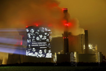 Activistas de Greenpeace proyectan la leyenda "el carbón destruye nuestro futuro" en la torre de enfriamiento de la usina a lignito de Neurath, en el oeste de Alemania, viernes 10 de noviembre de 2017.