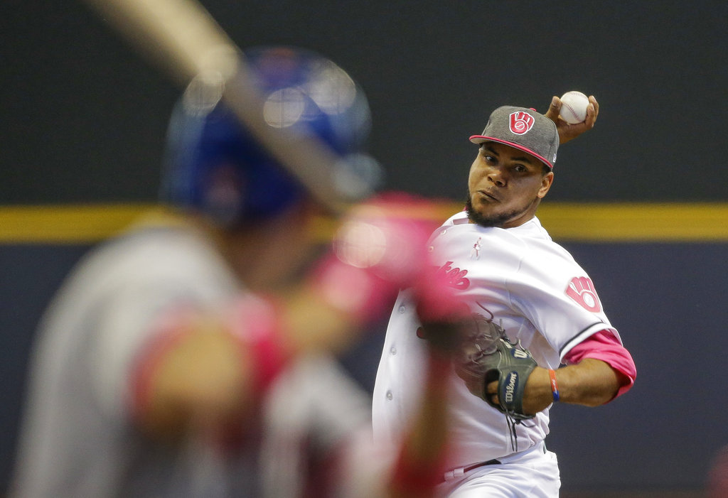 ARCHIVO - En esta foto del 14 de mayo de 2017, Wily Peralta de los Cerveceros de Milwaukee lanza ante los Mets de Nueva York. El pitcher dominicano firmó un contrato de una temporada con los Reales de Kansas City. (AP Foto/Tom Lynn)