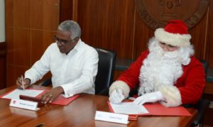 El rector INTEC, Rolando M. Guzmán, al firmar un acuerdo de cooperación con Santa Claus