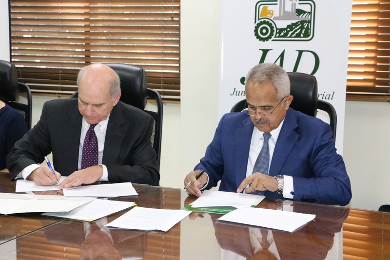 Jim Carr, presidente ejecutivo de Blue Book, Osmar Benítez, presidente ejecutivo de la JAD, firman la alianza.