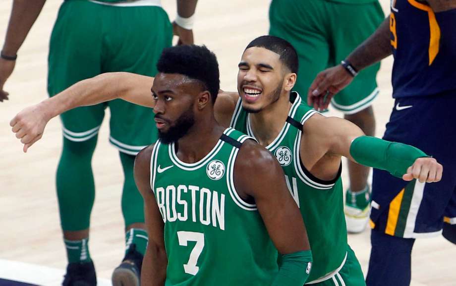 Jayson Tatum (detrás) abraza a Jaylen Brown (7) tras el enceste de triple de Brown para vencer al Jazz de Utah, el miércoles 28 de marzo de 2018 en Salt Lake City. (AP Foto/Rick Bowmer)