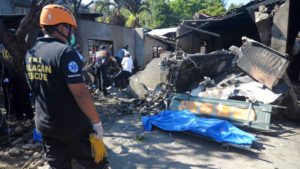Un rescatista observa un cadáver recuperado de entre los escombros luego de que una avioneta Piper PA-23 Apache se estrellara el sábado 17 de marzo de 2018 en una zona de viviendas en Plaridel, al norte de Manila. (AP Foto)