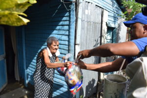 Un miembro del Plan Social entrega una ayuda a una de las familias afectadas por las lluvias en San Cristóbal   