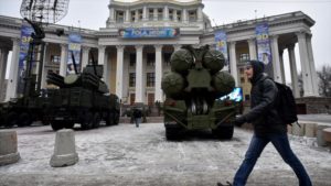 Vladimir Putin resalta su poderoso Armamento. Un hombre pasa por delante de un sistema antimisiles de Rusia S-400