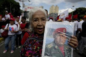 Una simpatizante del gobierno posa con un retrato del fallecido presidente de Venezuela Hugo Chávez durante un acto proselitista a favor del presidente Nicolás Maduro, quien busca la reelección