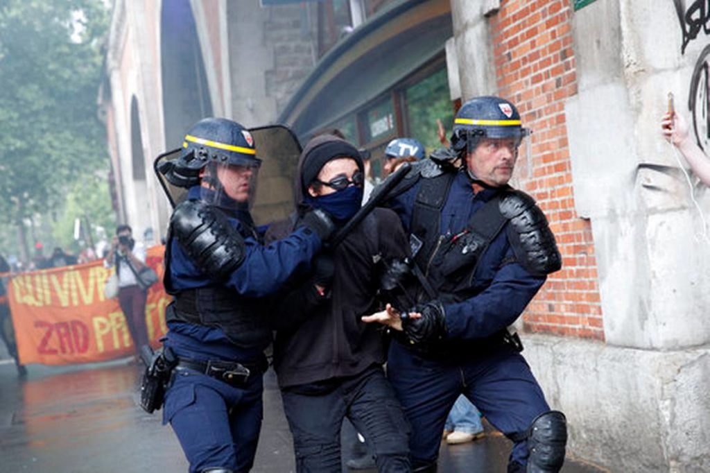 Policías de París detienen a un manifestante durante enfrentamientos entre los elementos de seguridad y jóvenes enmascarados