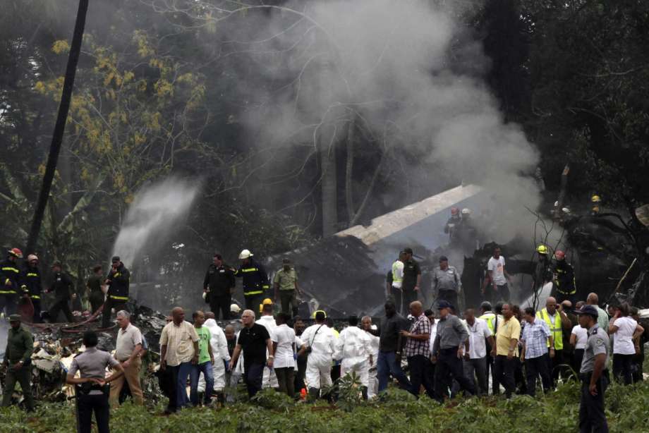 Presidente cubano Miguel Díaz-Canel, tercero de la izquierda, se aleja del lugar donde un Boeing 737 con más de 100 personas a bordo cayó a un campo de Yuca cerca de La Habana, Cuba, 18 de mayo de 2018. (AP Foto/Enrique de la Osa)