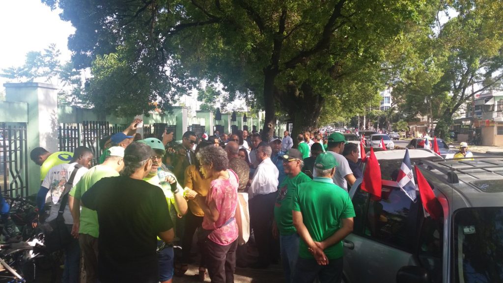 Miembros del colectivo Somos Pueblo y otros ciudadanos congregados frente al estadio Quisqueya para el carreteo