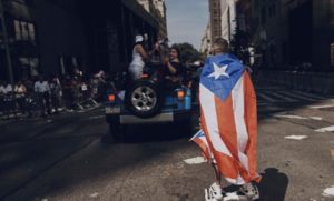 Un hombre con la bandera de Puerto Rico camina por la Quinta Avenida durante el Desfile Puertorriqueño de Nueva York el 11 de junio de 2017. (AP Foto/Andres Kudacki)