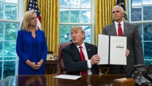 El presidente Donald Trump sostiene la orden ejecutiva que firmó para poner fin a la separación de familias en la frontera, durante un evento en la oficina oval de la Casa Blanca en Washington