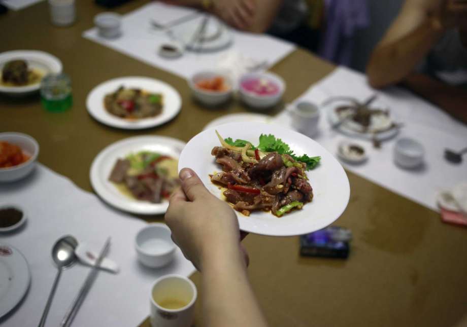 Un mesero sirve un platillo hecho con carne de perro en el restaurante House of Sweet Meat, especializado en carne de perro, en Pyongyang, Corea del Norte el miércoles 25 de julio de 2018. (AP Foto/Dita Alangkara)