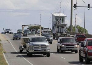 Numerosos automovilistas cruzan un puente levadizo en Wrightsville Beach, Carolina del Norte, mientras evacuan la zona ante la llegada del huracán Florence, el martes 11 de septiembre de 2018. (AP Foto/Chuck Burton)