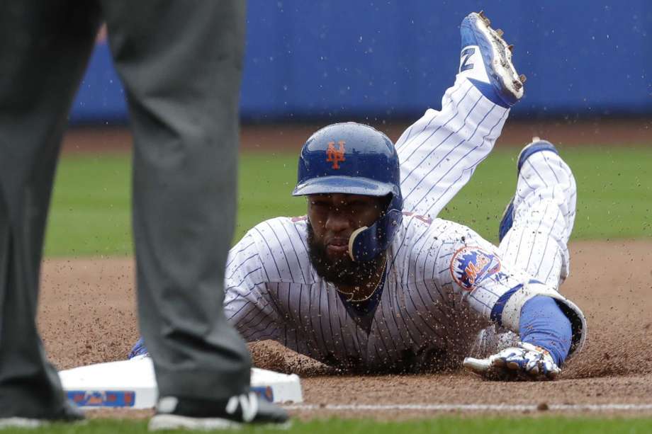 El dominicano Amde Rosario, de los Mets de Nueva York, se desliza en la antesala luego de conectar un triple ante los Filis de Filadelfia, el domingo 9 de septiembre de 2018 (AP Foto/Mark Lennihan)