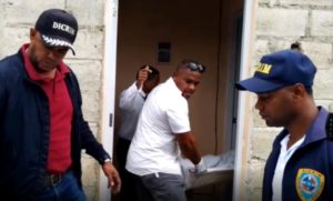 Momento en que las autoridades levantan el cadáver de mujer asesinada por su hijastro en Higüey