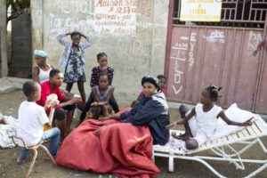 Unas personas se reúnen el lunes 8 de octubre de 2018 afuera de sus casas en la ciudad de Port-de-Paix, luego de que un sismo de magnitud 5,9 azotó Haití el fin de semana. (AP Foto/Dieu Nalio Chery)