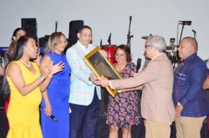 Trajano Santana recibe del personal de la ONDA una placa de reconocimiento