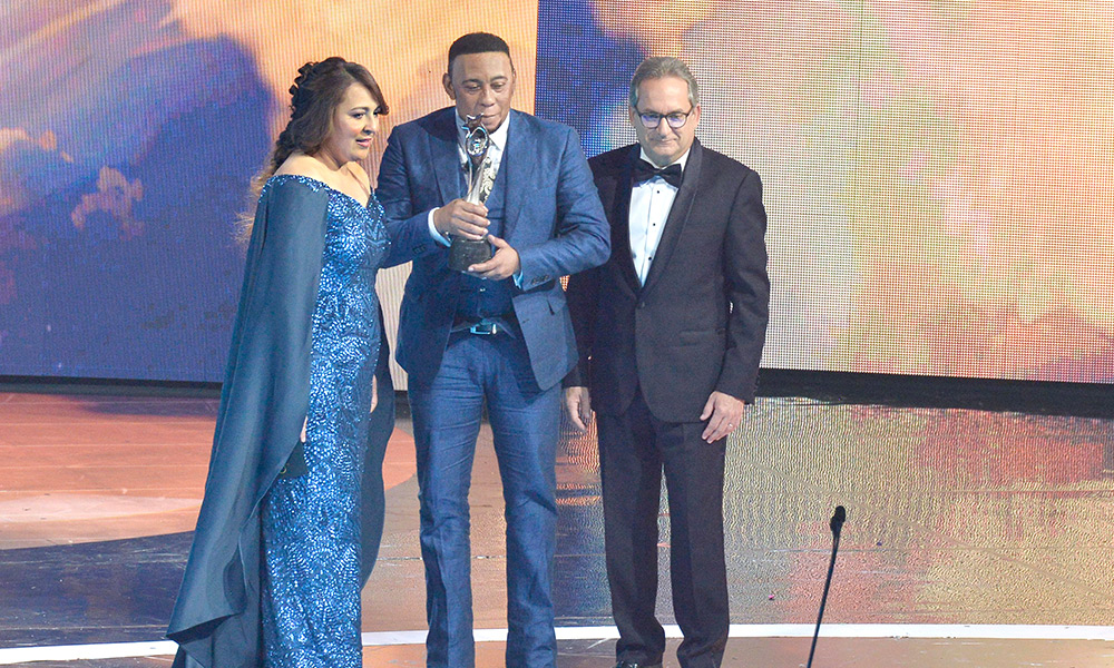 El bachatero Anthony Santos sostiene la estatuilla del Gran Soberano que recibió anoche en el Teatro Nacional.