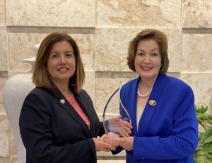 Lucile Houellemont entrega el reconocimiento a Clara Elena Jimenes Alfau, fundadora de dos de las principales compañías de seguridad privada del país.