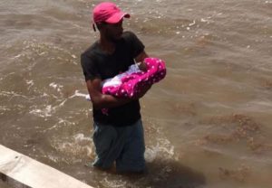 Hombre cruza muelle colapsado con bebé en brazos