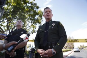 El subalguacil Jeff Hallock (d) habla con miembros de la prensa en el lugar de un tiroteo en la Iglesia Presbiteriana de Geneva en Laguna Woods, California (EE.UU.)